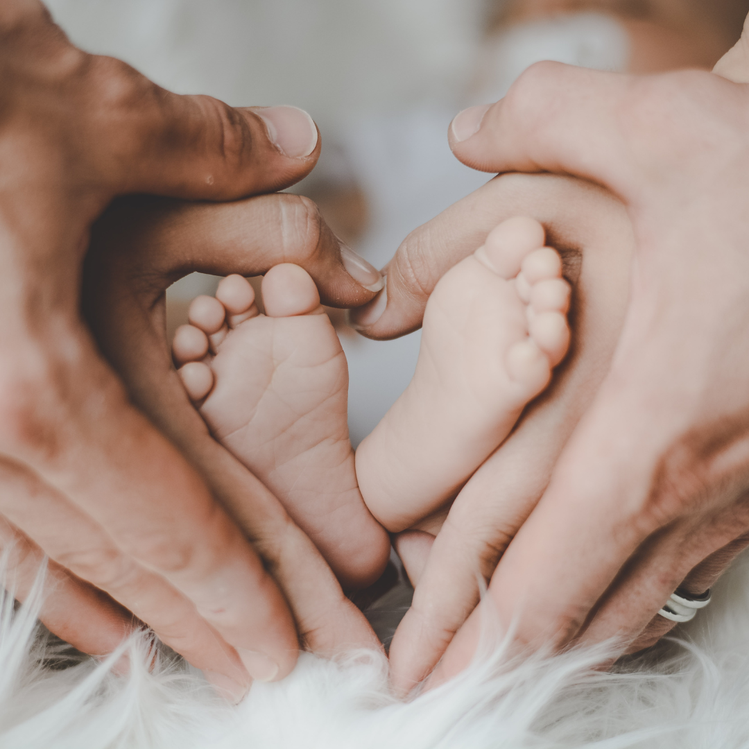 Handen ouders en kindervoetjes op witte ondergrond. PH waarde belangrijk voor baby